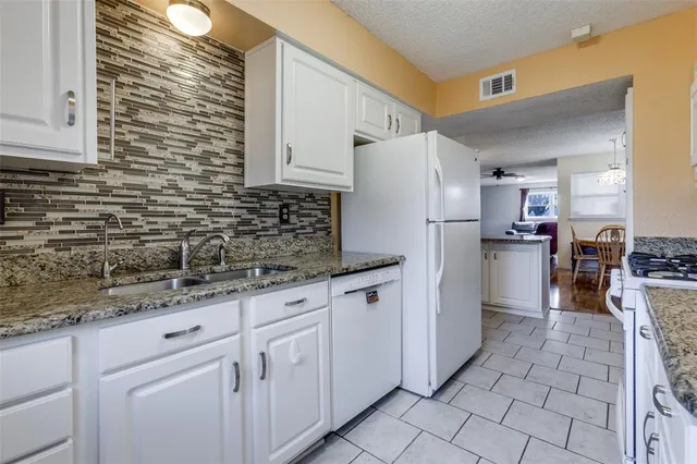 a kitchen with a sink a refrigerator and cabinets