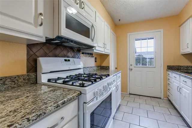 a kitchen with granite countertop a stove and a sink