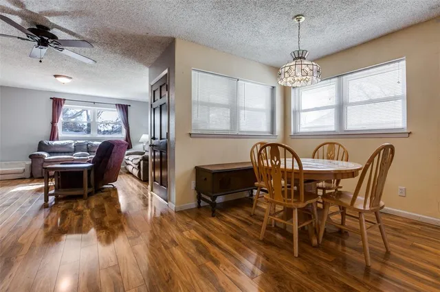 a view of a dining room with furniture a chandelier and wooden floor