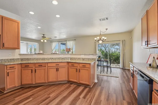 a kitchen with granite countertop a sink cabinets stainless steel appliances and a window