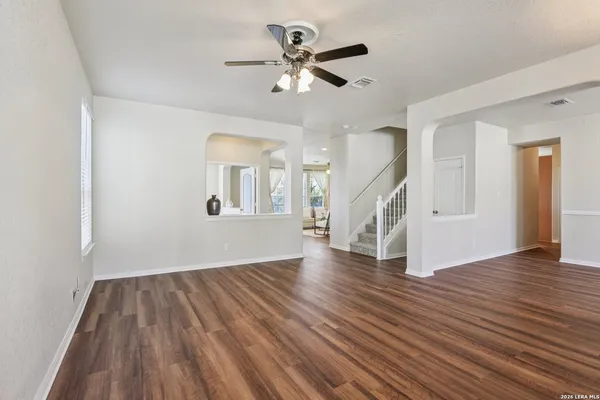 a view of an empty room with wooden floor and a window
