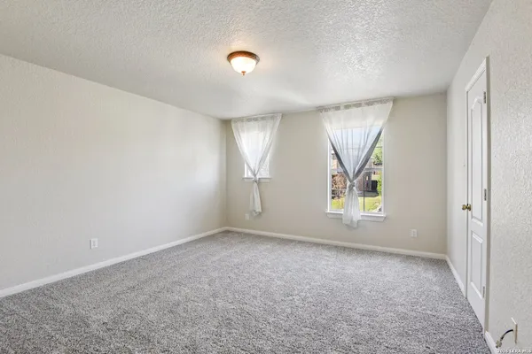 a bedroom with a bed couch chandelier and a window