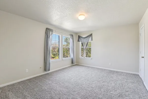a bed sitting in a bedroom next to a window