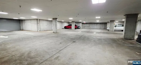 an empty room with kitchen view and a refrigerator