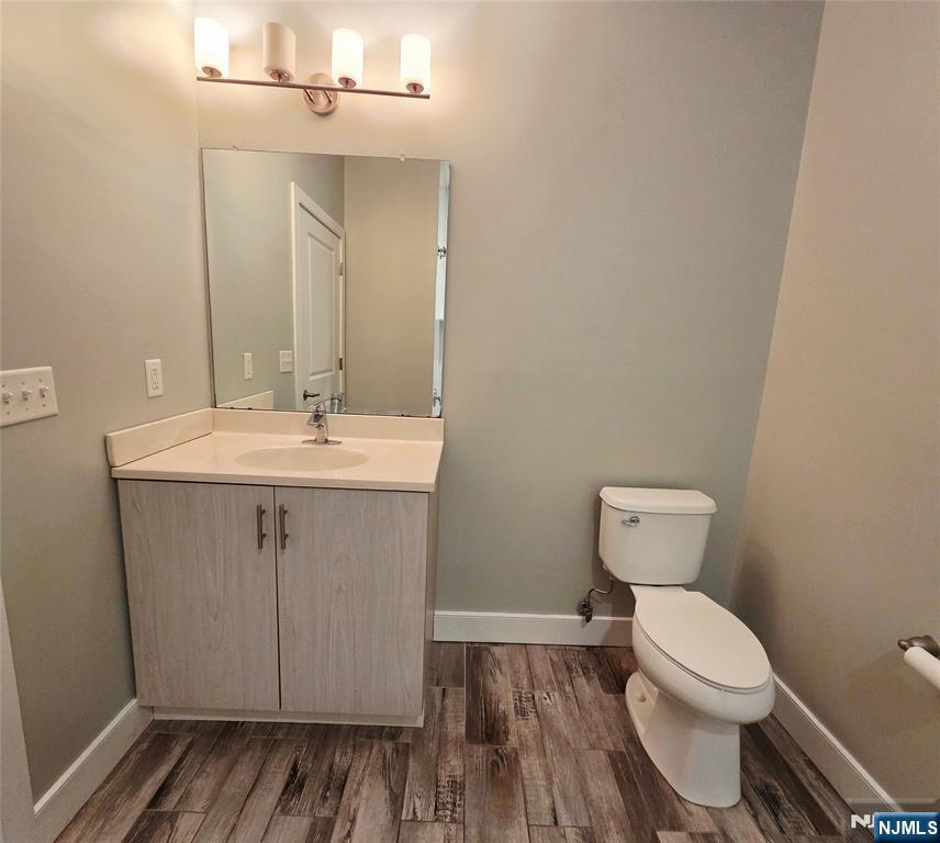 235 Ridge Road North Arlington, NJ 07031 - Photo 9 of 13 a bathroom with a toilet a sink and wooden floor