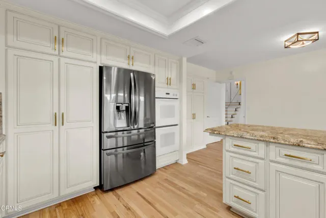 a kitchen with granite countertop white cabinets and stainless steel appliances