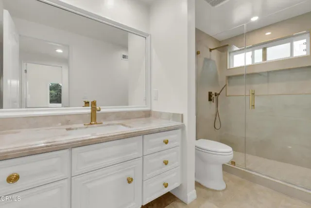 a bathroom with a granite countertop sink a toilet and a bathtub