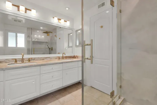 a bathroom with a granite countertop sink mirror and double