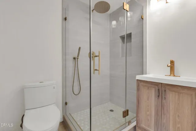 a bathroom with a shower sink mirror and toilet