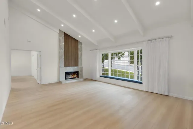 a view of an empty room with a window and fireplace