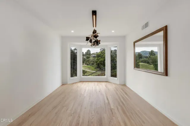 a view of a room with wooden floor chandelier and a window