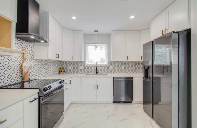 a kitchen with white cabinets and stainless steel appliances