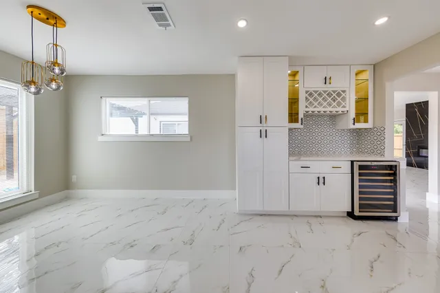 a view of a dining room and livingroom with furniture wooden floor a chandelier