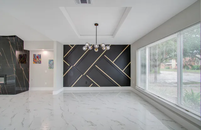 a view of a hallway with a chandelier fan and windows