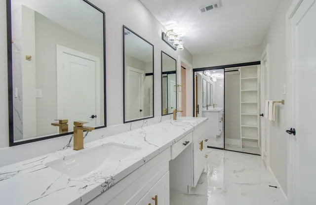a bathroom with a granite countertop sink mirror and shower