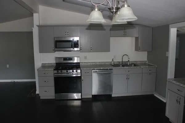 a kitchen with stainless steel appliances a sink dishwasher a refrigerator and a microwave oven