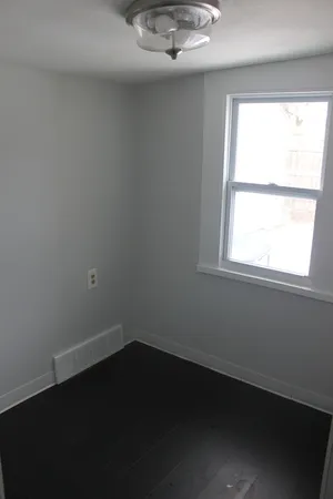 a view of a small space with wooden floor and a window
