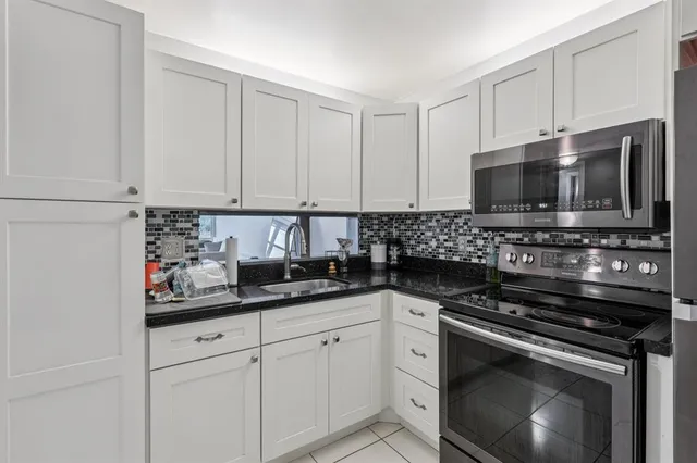a kitchen with stainless steel appliances granite countertop a stove a sink and a microwave