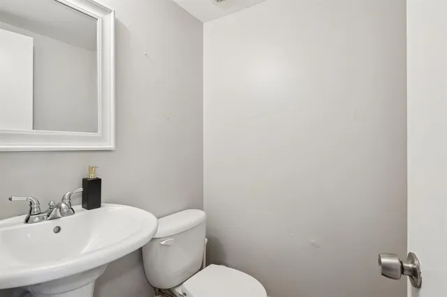 a bathroom with a toilet sink and mirror
