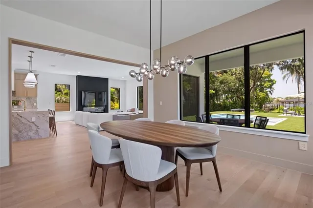 a dining room with furniture a chandelier and wooden floor