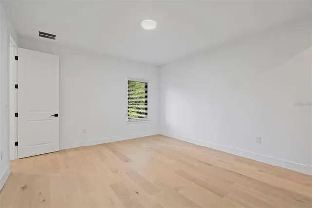 a view of a room with a large window and wooden fence