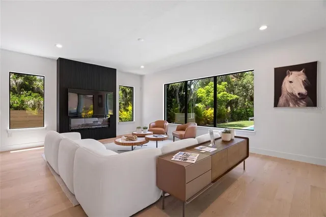a living room with fireplace furniture and a large window