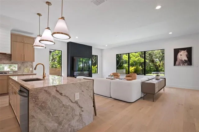 a living room with kitchen island furniture and a chandelier
