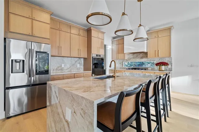 a kitchen with stainless steel appliances granite countertop a stove a sink and a refrigerator