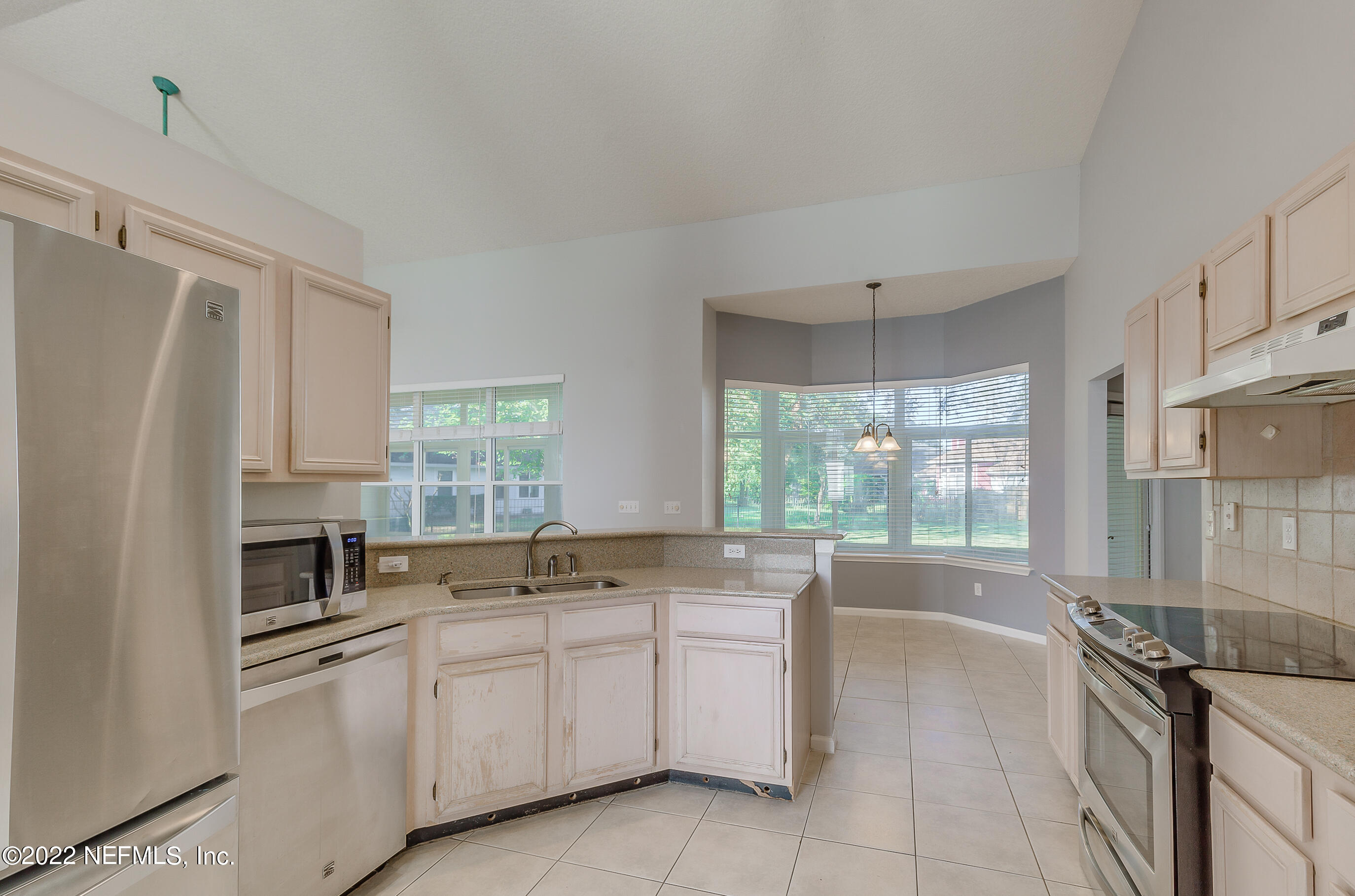 2004 Water Crest Drive Fleming Island, FL 32003 - Photo 16 of 51 a kitchen with granite countertop white cabinets white appliances a sink and a window