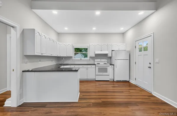 a kitchen with stainless steel appliances granite countertop a refrigerator and a stove top oven