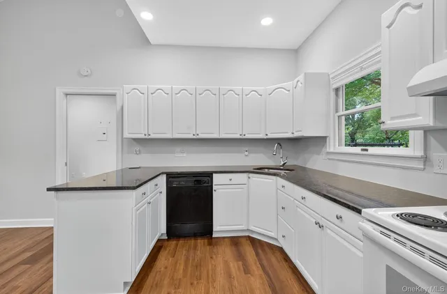 a kitchen with granite countertop white cabinets and white appliances