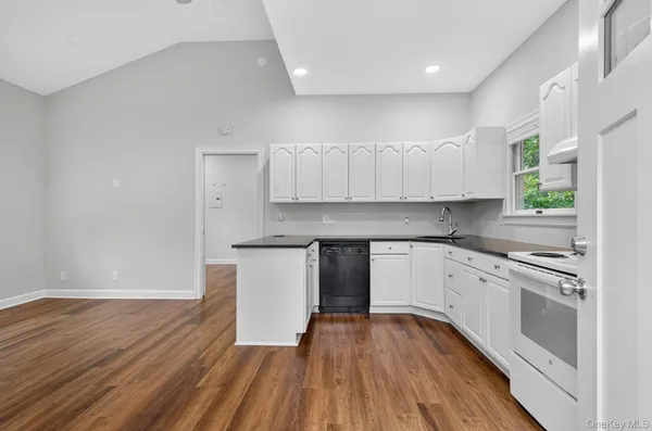 a kitchen with granite countertop wooden floors stainless steel appliances and cabinets