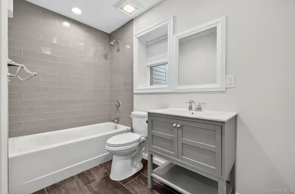 a bathroom with a tub a toilet and a shower
