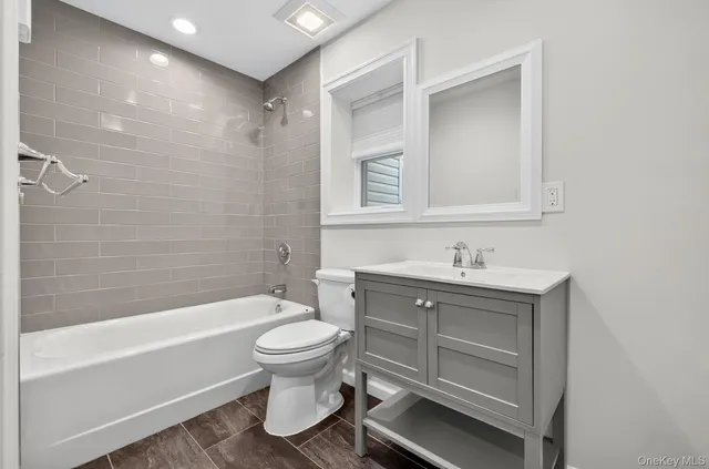 a bathroom with a tub a toilet and a shower