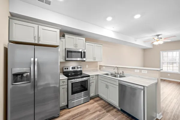 a kitchen with stainless steel appliances granite countertop a stove a sink and a refrigerator