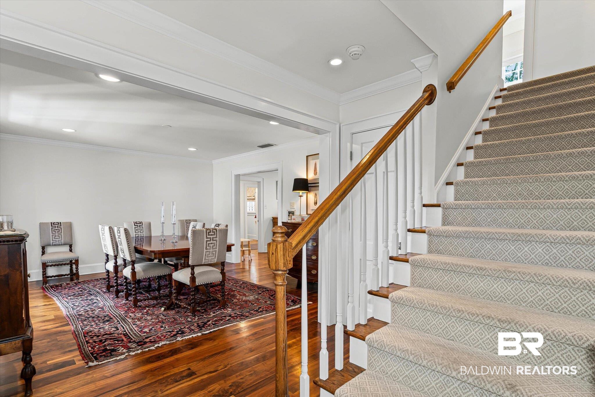 513 Spring Park Drive East Mobile, AL 36608 - Photo 19 of 44 Dining area featuring crown molding, dark wood-type flooring, recessed lighting, and stairs