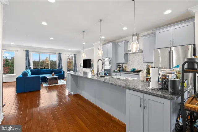 a large kitchen with kitchen island a large counter top space a sink stainless steel appliances and cabinets