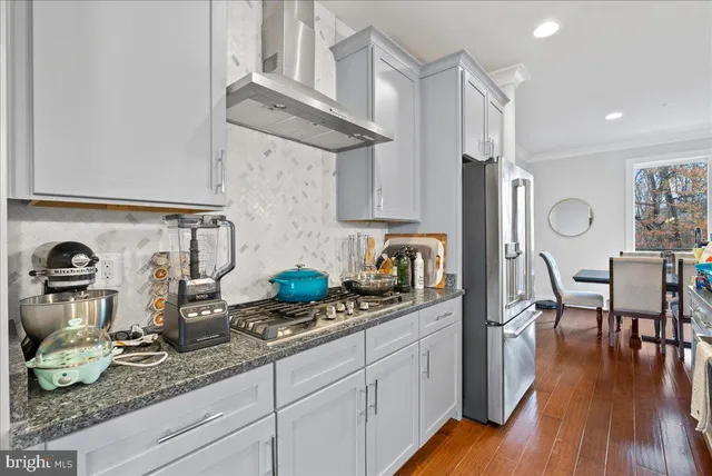 a kitchen with stainless steel appliances granite countertop a sink stove and wooden floor