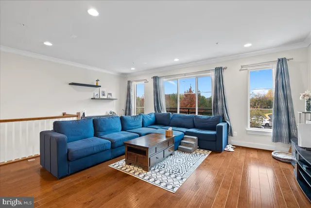 a living room with furniture and a window with wooden floor