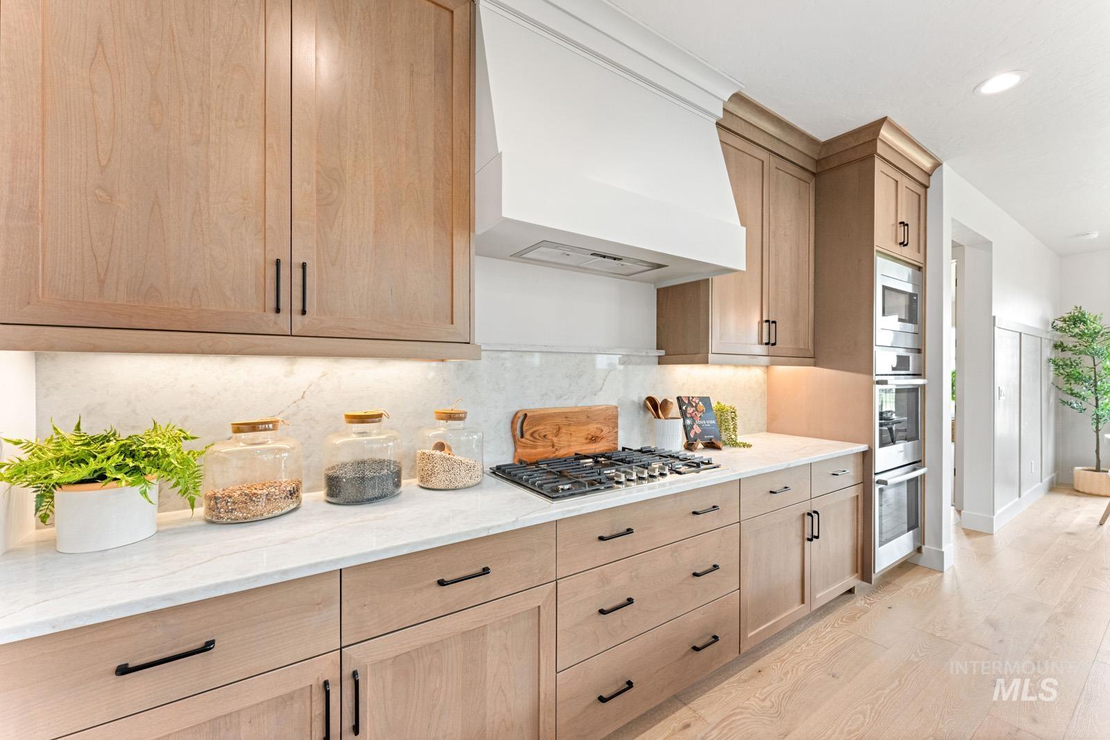 6792 Saddle Bred Way Star, ID 83669 - Photo 11 of 50 Kitchen featuring light stone countertops, decorative backsplash, light wood finished floors, recessed lighting, and stainless steel appliances