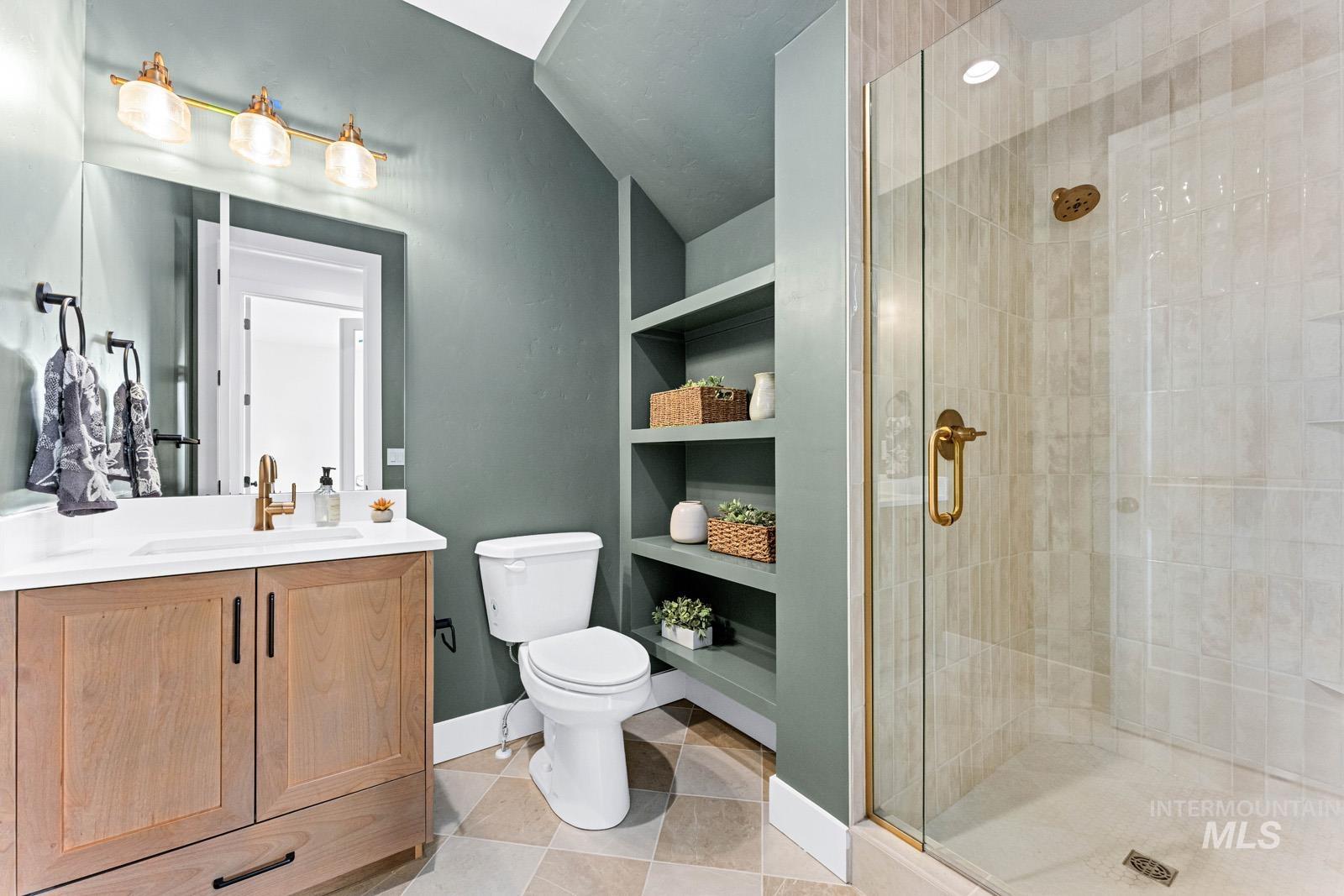 6792 Saddle Bred Way Star, ID 83669 - Photo 15 of 50 Full bath featuring built in shelves, a shower stall, vanity, and light tile patterned flooring