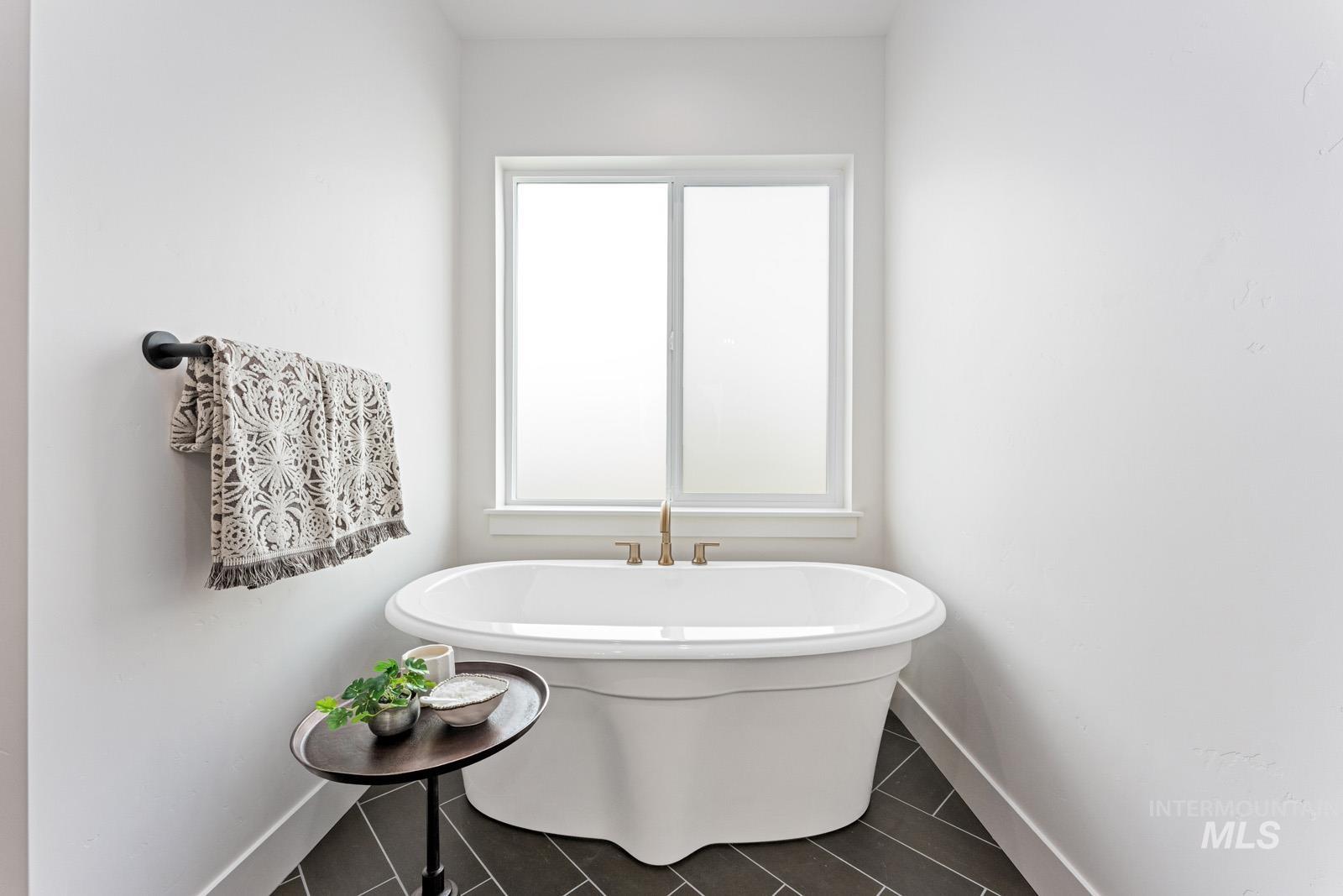 6792 Saddle Bred Way Star, ID 83669 - Photo 19 of 50 Full bathroom with a freestanding bath and baseboards