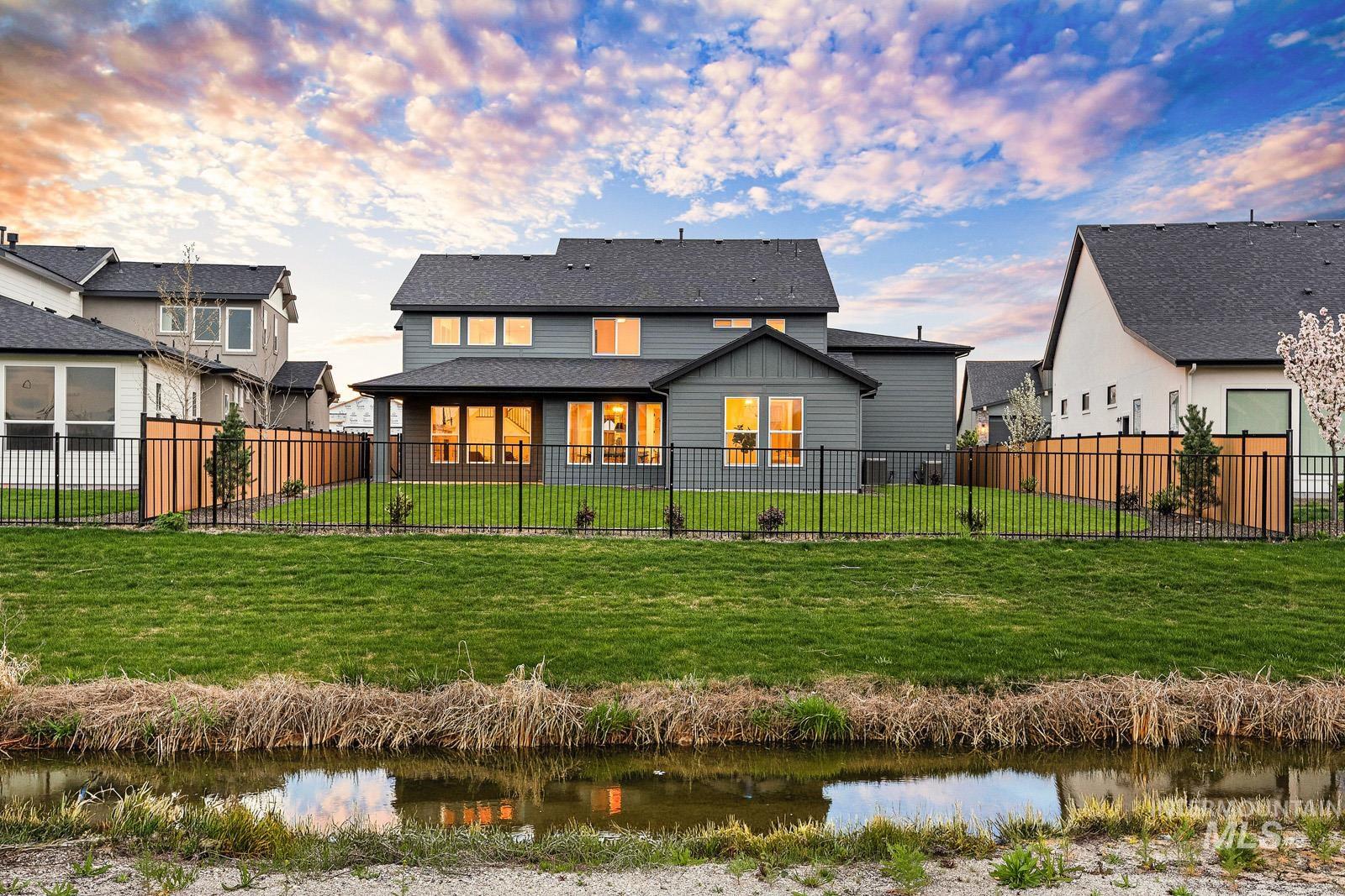 6792 Saddle Bred Way Star, ID 83669 - Photo 2 of 50 Rear view of house featuring a water view, a fenced backyard, a patio area, and roof with shingles