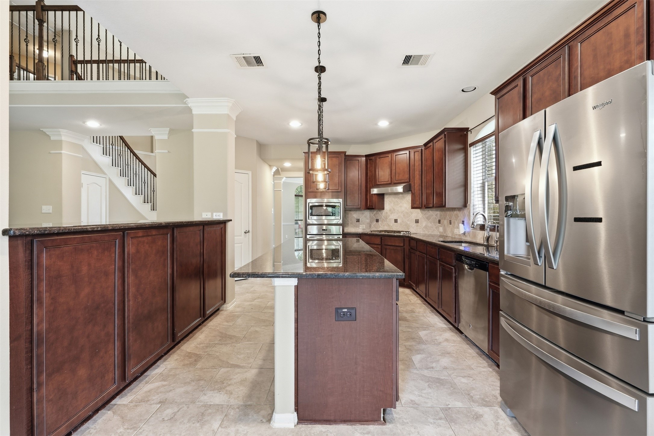 12410 Adams Ridge Lane Humble, TX 77346 - Photo 13 of 33 The chefs kitchen features a large island, build in ovens, a gas burner stove, and lots of cabinet space.