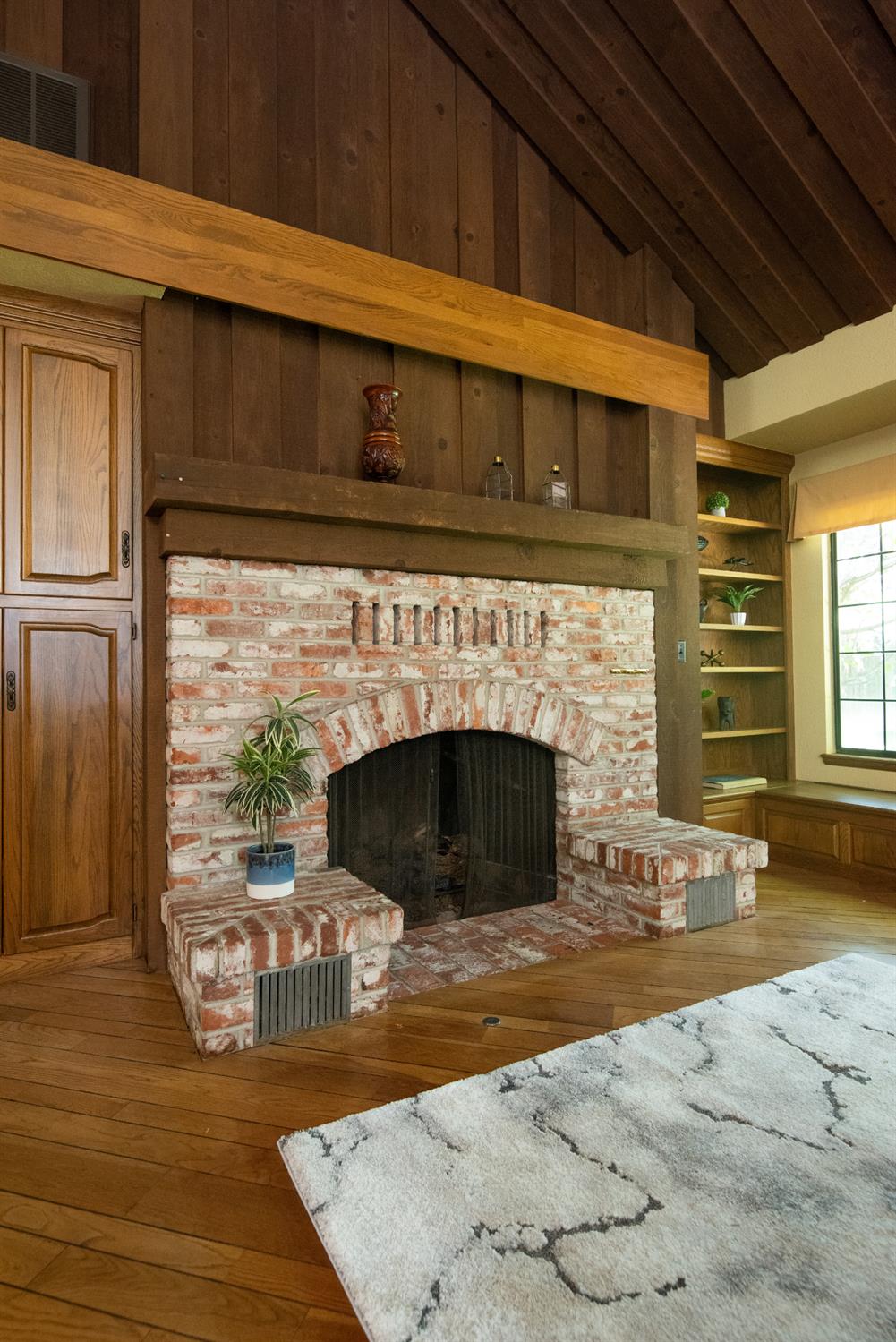 925 Scenic Court Modesto, CA 95355 - Photo 15 of 62 a living room with a fireplace a rug and a window