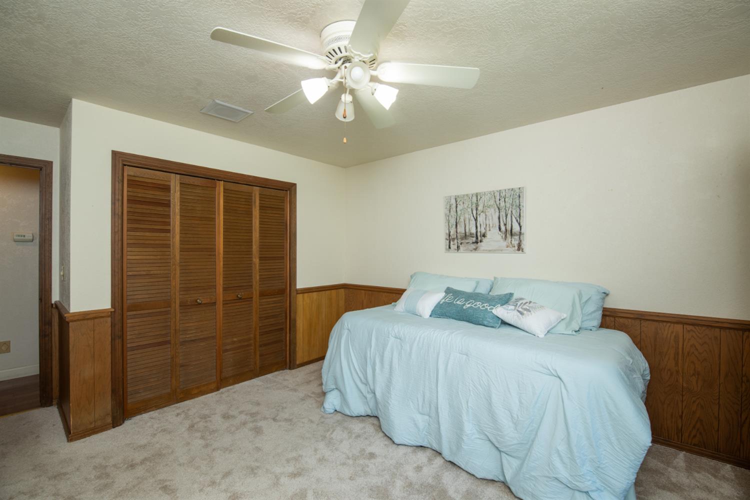 925 Scenic Court Modesto, CA 95355 - Photo 43 of 62 a bedroom with a large bed and a chandelier