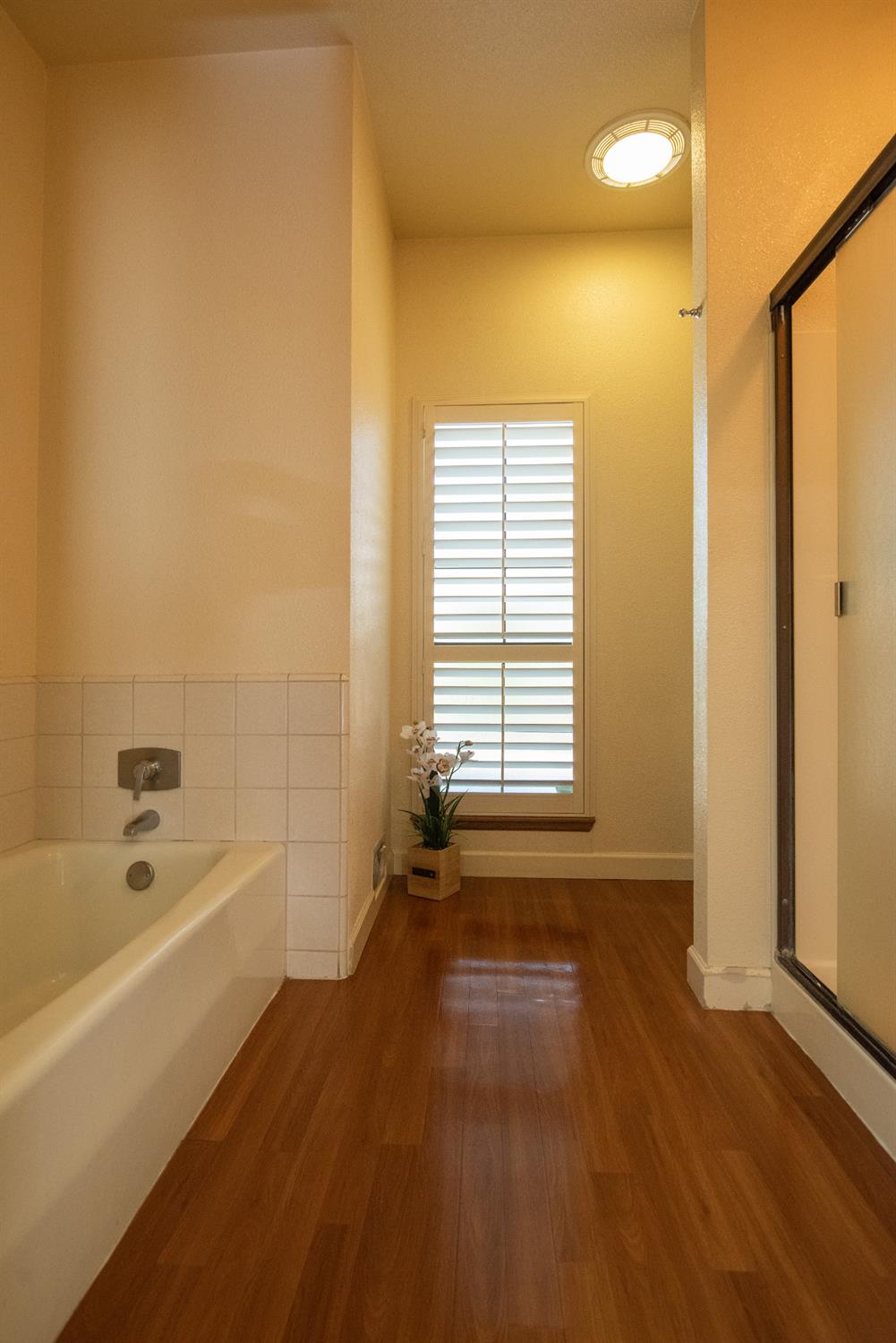925 Scenic Court Modesto, CA 95355 - Photo 53 of 62 a view of a bathroom with tub window and wooden floor