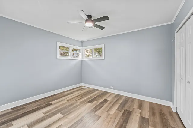 a view of empty room with wooden floor