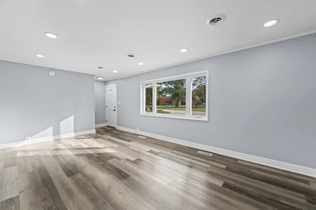 a view of empty room with wooden floor