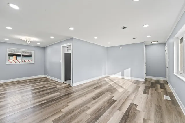 a view of empty room with wooden floor